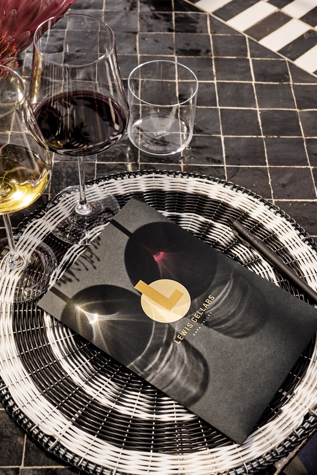 Lewis Cellars tasting menu with red and white wine on a woven charger