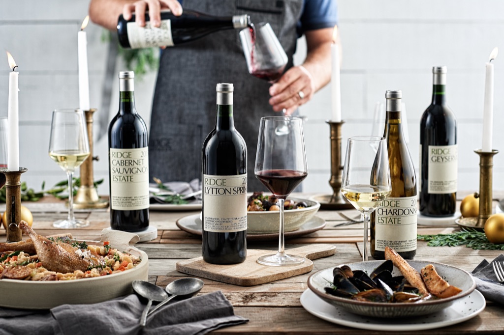 Holiday table set with Ridge Vineyards bottles, candlesticks, and shared dishes